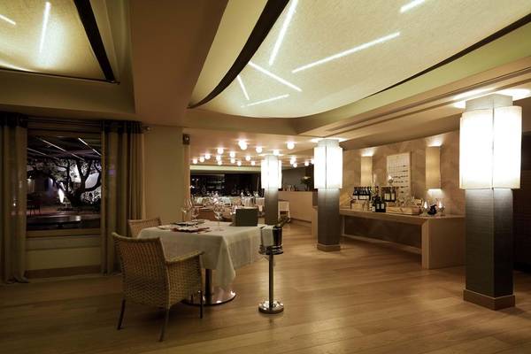 Innenbereich des Restaurants im Elounda Bay Palace Hotel mit Holzboden und Tisch.