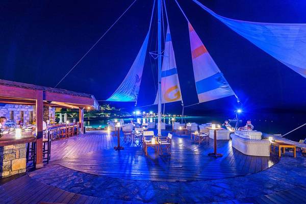 Terrasse des Elounda Bay Palace Hotels bei Nacht mit blauen Beleuchtung und Blick aufs Meer