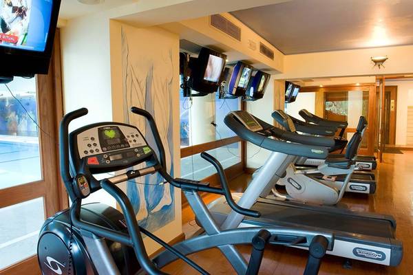 Fitnesscenter im Elounda Bay Palace mit mehreren Laufbändern und Monitoren