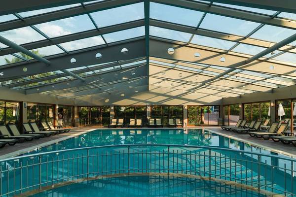 Innenpool des Primasol Hane Family Resort mit Glasdach und Sonnenliegen