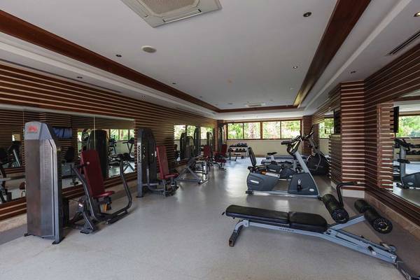 Fitnessstudio im Primasol Hane Family Resort mit verschiedenen Trainingsgeräten und Spiegeln.