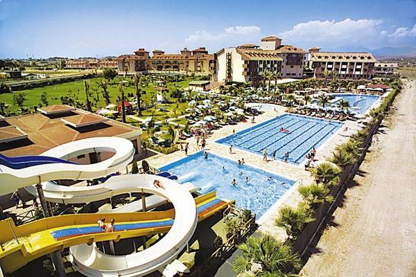 Luftaufnahme des Schwimmbadbereichs im Primasol Hane Family Resort mit Wasserrutschen und mehreren Pools.