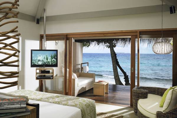 Zimmer im Taj Coral Reef Resort & Spa mit Blick auf das Meer, Fernseher und bequemen Möbeln.
