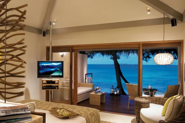 Zimmer mit Meerblick im Taj Coral Reef Resort & Spa mit Fernseher, Sofa und Blick auf den Ozean