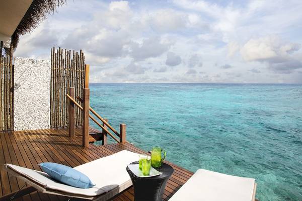 Terrasse des Taj Coral Reef Resorts mit Blick auf das Meer und zwei Liegen.