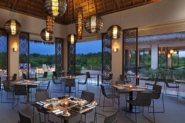 Innenansicht des Restaurants im Paradisus Playa del Carmen mit Tischen, Stühlen und Lampen.