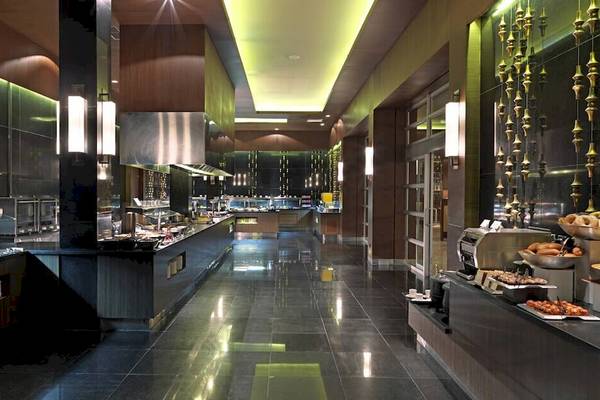 Innenansicht des Restaurants im Paradisus Playa del Carmen Hotel mit Speisen und glänzenden Böden.