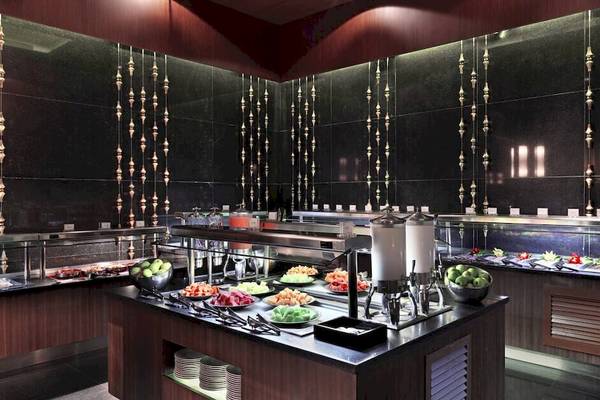 Buffetbereich im Paradisus Playa del Carmen mit verschiedenen Gerichten und einer dunklen Inneneinrichtung.