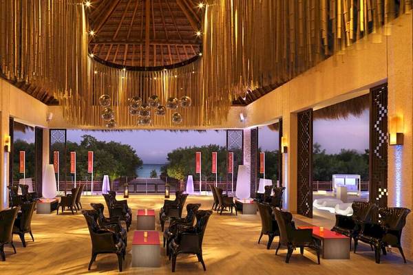 Loungebereich im Paradisus Playa del Carmen mit modernem Design, schwarzen Stühlen und Tischen, sowie einer atemberaubenden Aussicht auf das Meer.