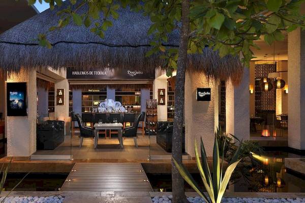 Außenbereich des Paradisus Playa del Carmen Hotels mit einem Tisch und Stühlen.