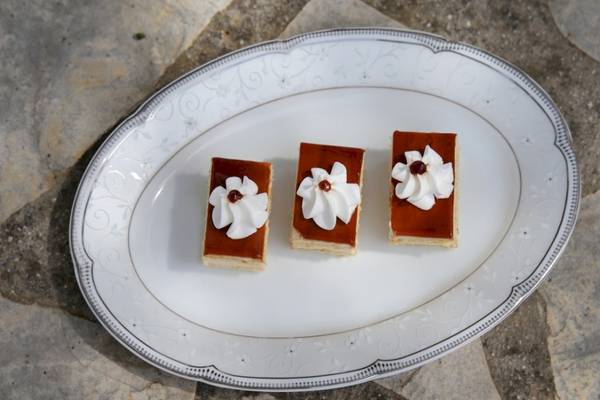 Dreieckigere Sahne-Desserts auf einem weißen Teller serviert
