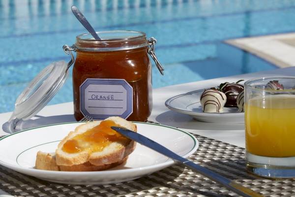 Frühstück am Pool im Paradise Hotel Corfu mit Marmelade, Toast, Schokoladen-Erdbeeren und Orangensaft.