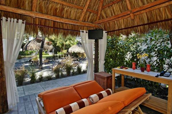 Innenbereich der Terrasse im Palms Hotel & Spa mit orangefarbenen Möbeln und einem Fernseher.