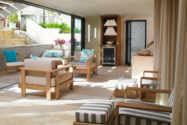 Lounge-Bereich im Palms Hotel & Spa mit Holzmöbeln, Kissen und Pflanzen.