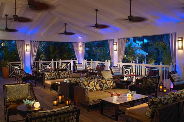 Terrasse des Palms Hotel & Spa mit beleuchteten Deckenventilatoren und Möbeln.
