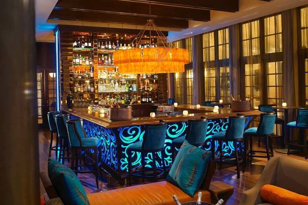 Bar im Palms Hotel & Spa mit blauen Beleuchtung und blauen Stühlen.