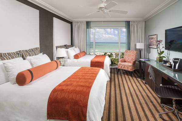 Zweibettzimmer im Palms Hotel & Spa mit Blick auf das Meer von einer Terrasse.