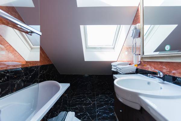 Best Western Plus Hotel Badezimmer mit Badewanne, Waschbecken und Spiegel.