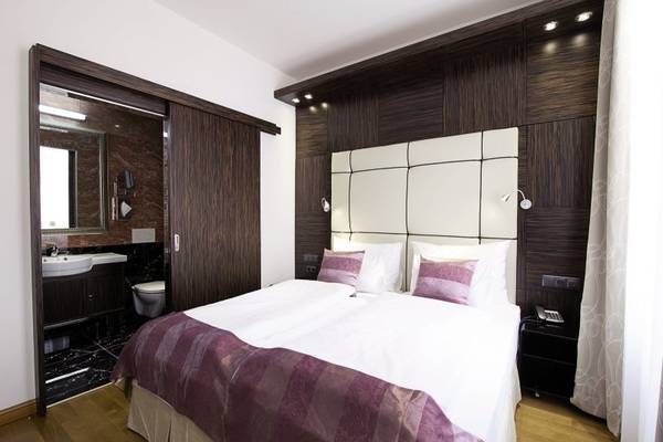 Innenansicht des Schlafzimmers im Best Western Plus Hotel mit Doppelbett, Dekor und Badezimmer.