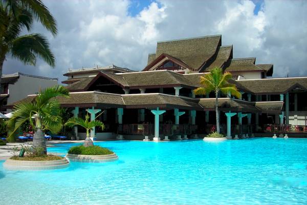 Außenbereich des Sofitel Mauritius L'Imperial Resort & Spa mit Swimmingpool und Palmen