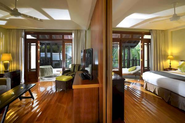 Zimmer im Sofitel Mauritius L'Imperial Resort & Spa mit Holzboden, Doppelbett und Fernseher.