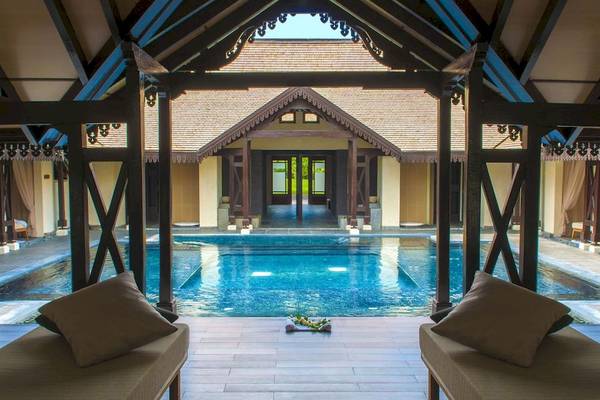 Poolbereich im Sofitel Mauritius L'Imperial Resort & Spa mit Loungemöbeln und Wasser.