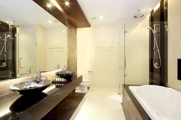 Ein modernes Badezimmer im Cape Panwa Hotel mit zwei Waschbecken, einer Toilette und einer Dusche.