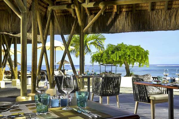 Außenbereich des Sofitel Mauritius L'Imperial Resorts & Spa mit Tischen und Stühlen und Meerblick.