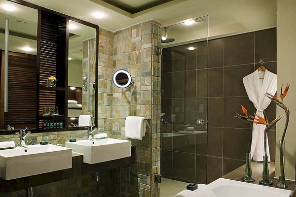 Badezimmer im Sofitel Mauritius L'Imperial Resort & Spa mit zwei Waschbecken, einer Dusche und einer Badewanne.