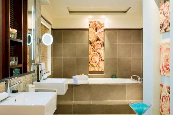 Badezimmer im Sofitel Mauritius L'Imperial Resort & Spa mit Badewanne, zwei Waschbecken und Dekor