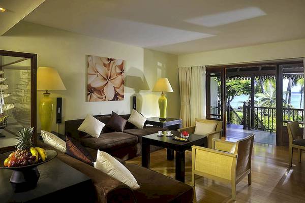 Wohnzimmer des Sofitel Mauritius L'Imperial Resort & Spa mit Möbeln, Lampen und einer Aussicht auf den Ozean.