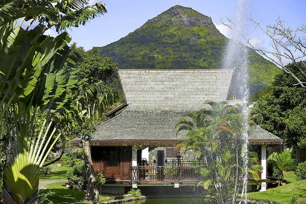 Außenansicht des Sofitel Mauritius L'Imperial Resorts & Spa mit einem Brunnen und grüner Landschaft