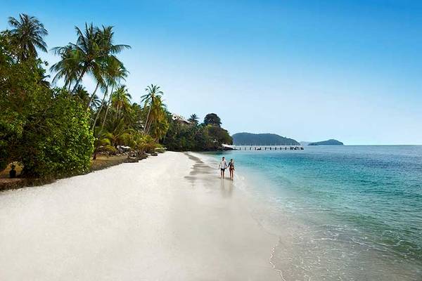 Strand mit Palmen und zwei Personen am Cape Panwa Hotel