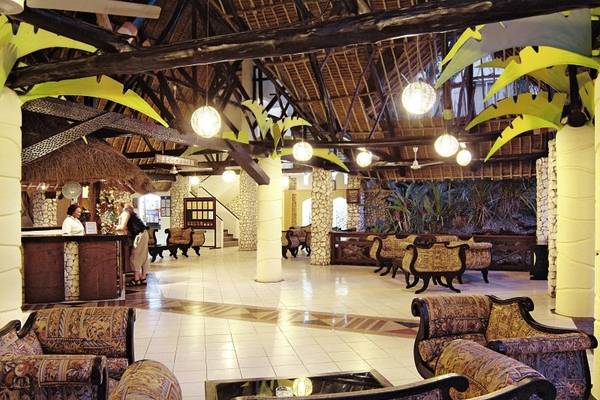 Lobby des Bamburi Beach Hotels mit Holzmöbeln, Deckenventilatoren und Pflanzen.