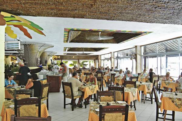 Innenansicht des Restaurants im Bamburi Beach Hotel mit Gästen an Tischen und einem farbenfrohen Interieur.