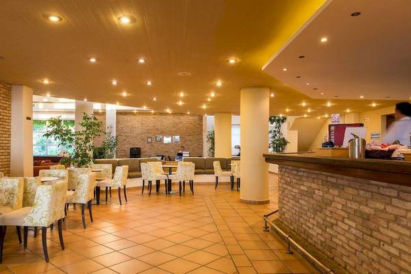 Lobby des Allsun Hotel Zorbas Village mit gefliesten Boden und weißen Stühlen.