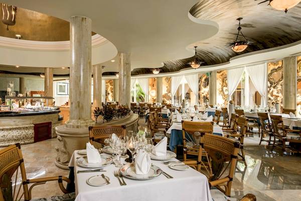 Innenansicht des Restaurants im Iberostar Paraiso del Mar Hotel mit geräumigen Tischen und Stühlen, einem eleganten Buffet und einer geräumigen Atmosphäre.