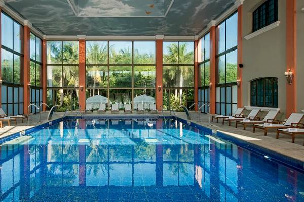 Innenpool im Iberostar Paraiso del Mar Hotel mit Lounge-Sesseln und Glaswänden.