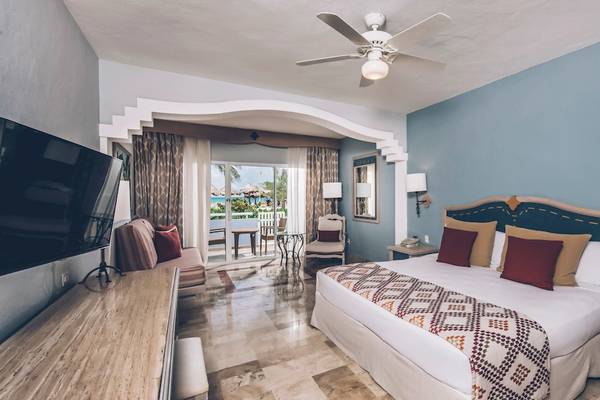Ein Hotelzimmer im Iberostar Paraiso del Mar mit einem großen Bett, Fernseher und Balkon.