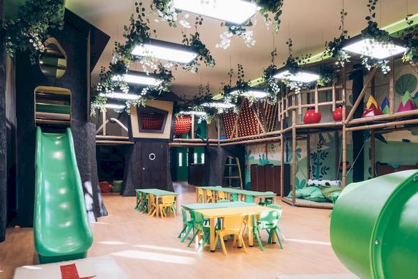 Der Kinderspielbereich des Iberostar Paraiso del Mar mit bunten Farben, Tischen, Stühlen und Spielgeräten.