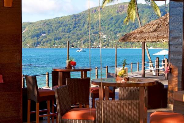 Ausblick von der Terrasse des Fisherman's Cove Resorts auf das Meer mit blauem Himmel und grünen Bergen.