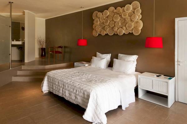 Schlafzimmer im Fisherman's Cove Resort mit Doppelbett, weißen Kissen, roter Beleuchtung und Holzwanddekoration.