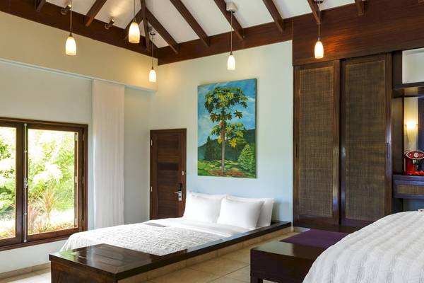 Schlafzimmer im Fisherman's Cove Resort mit zwei Betten, Fenstern und einer Wandmalerei.