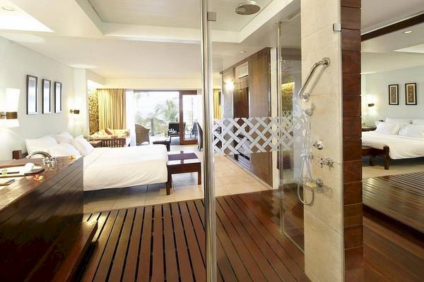Innenansicht eines Schlafzimmers im Fisherman's Cove Resort mit Doppelbett, Dusche und Wohnbereich.