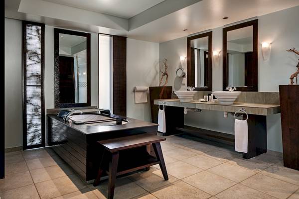 Badezimmer im Fisherman's Cove Resort mit Badewanne, Waschbecken und Spiegeln.