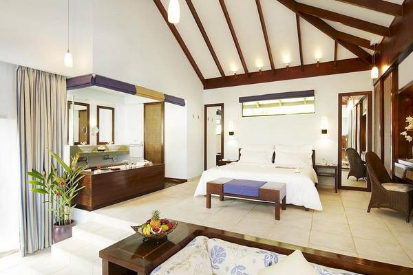 Innenansicht des Schlafzimmers im Fisherman's Cove Resort mit Bett, Sofa und Badezimmerbereich.