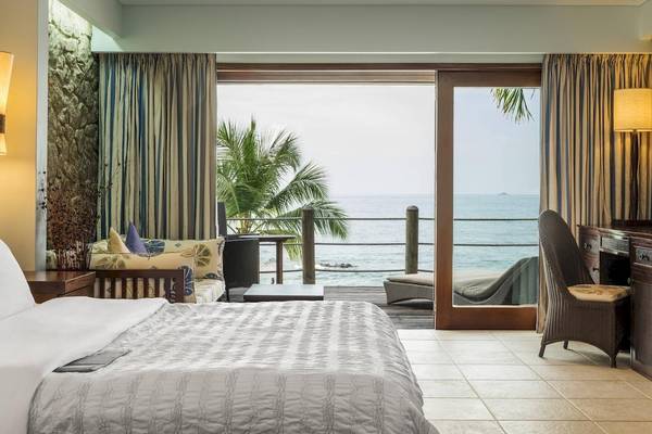 Zimmer mit Meerblick im Fisherman's Cove Resort mit großem Bett und Balkon.
