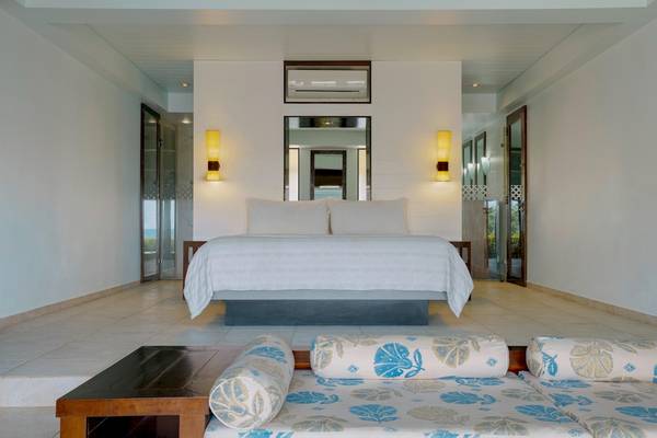 Schlafzimmer im Fisherman's Cove Resort mit Doppelbett, Wandleuchten und offenen Türen.