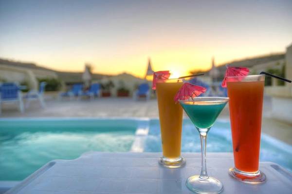 Drei Cocktails mit Strohhalmen am Pool des Saint Patrick's Hotel Gozo bei Sonnenuntergang