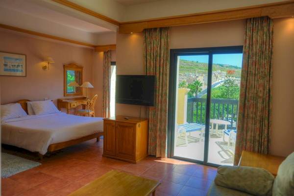 Zimmer im Saint Patrick's Hotel Gozo mit Bett, Fernseher und Balkon